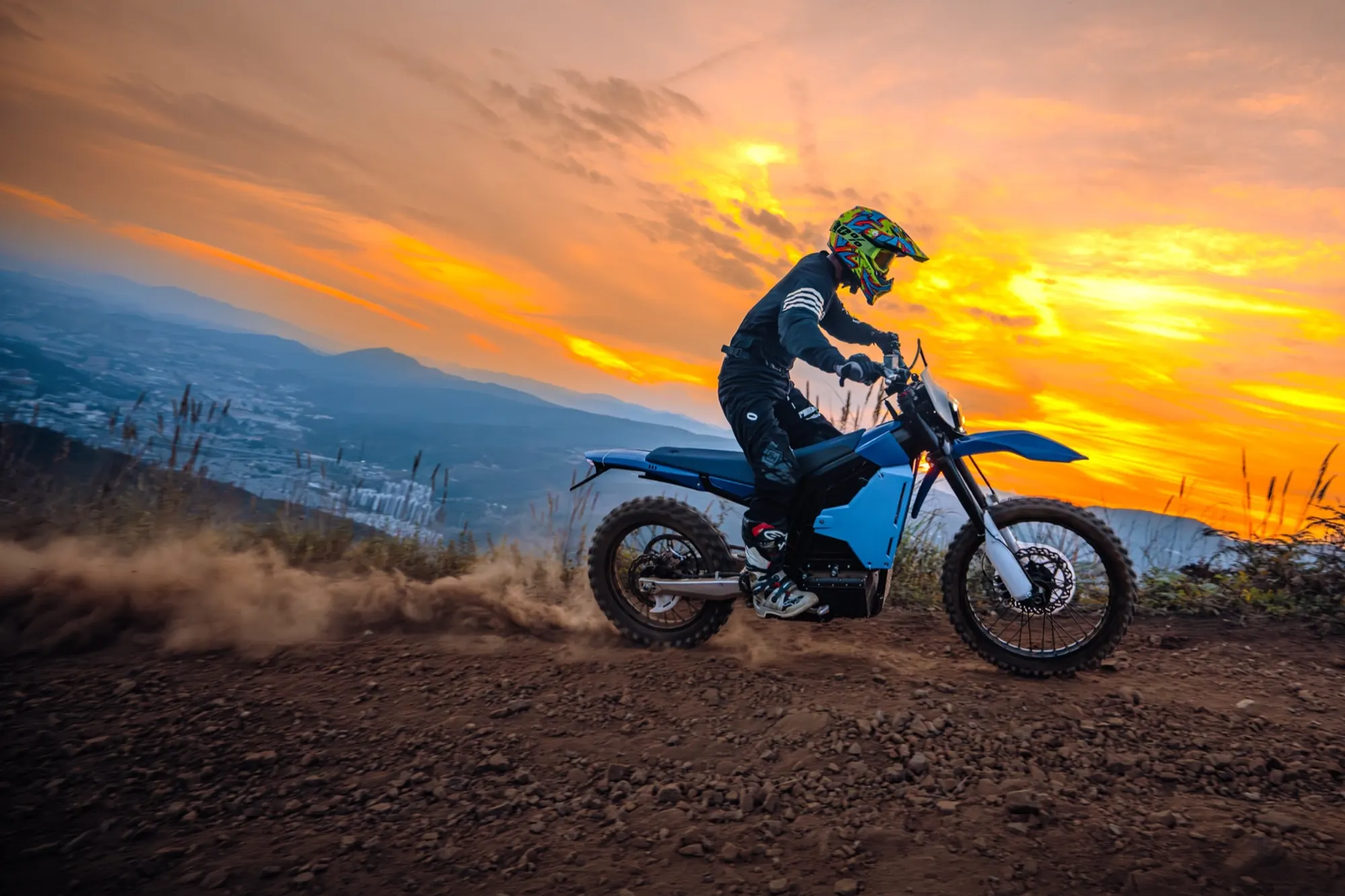 Rider climbing a mountain trail at sunset